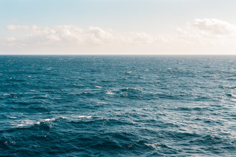 Tranquil ocean view under a clear sky, capturing the serene beauty of the expansive water.